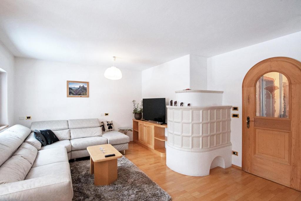 - un salon avec un canapé et une cheminée dans l'établissement Mountain Living Apartment Idylia, à Ortisei