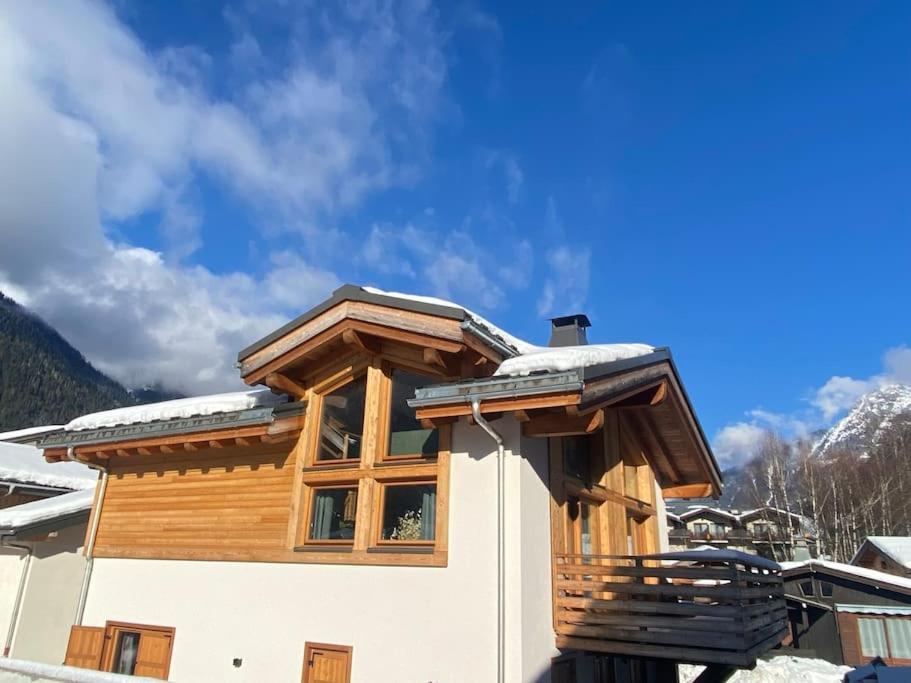 a house with a wooden roof with snow on it at Chalet Isabella : cozy & comfy in central Chamonix in Chamonix