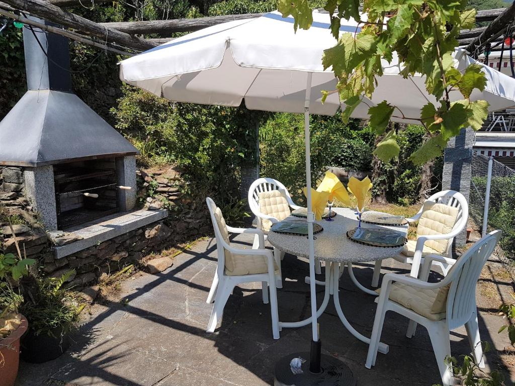 mesa y sillas con sombrilla y parrilla en "Vista Bellissima", en Brissago