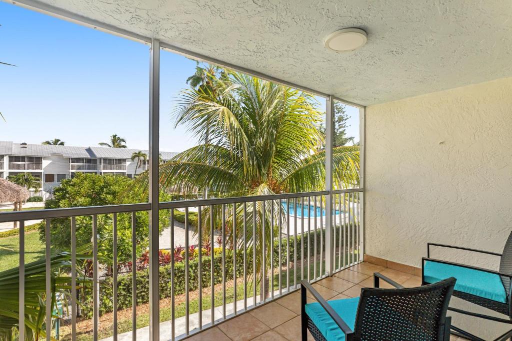 a balcony with a view of a palm tree and a pool at Ohana Keys in Key Largo