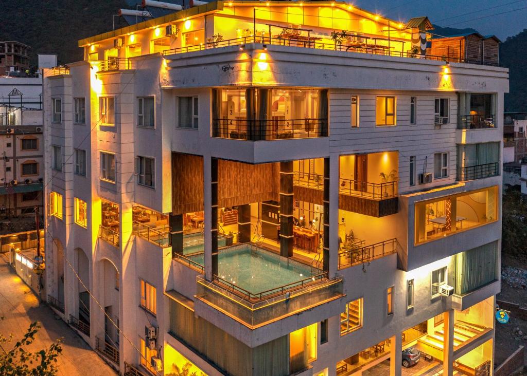 un gran edificio blanco con una piscina frente a él en Moustache Rishikesh Luxuria en Rishīkesh