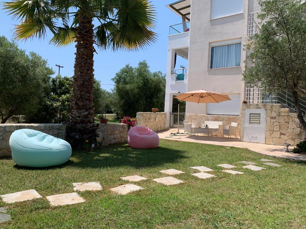 un patio con dos bolsas de frijoles y una palmera en Villa Evita , suites 1, Athytos,63m2,a/c,privacy, en Afitos