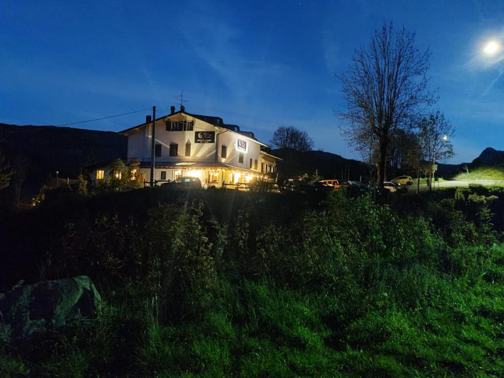 a house sitting on top of a hill at night at La Buca delle Fate in Pievepelago