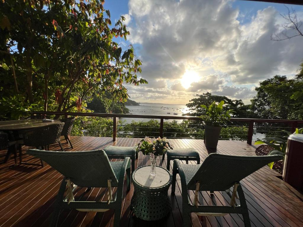 d'une terrasse avec des chaises et une table offrant une vue sur l'océan. dans l'établissement Passárgada Pousada e Restaurante, à Morro de São Paulo