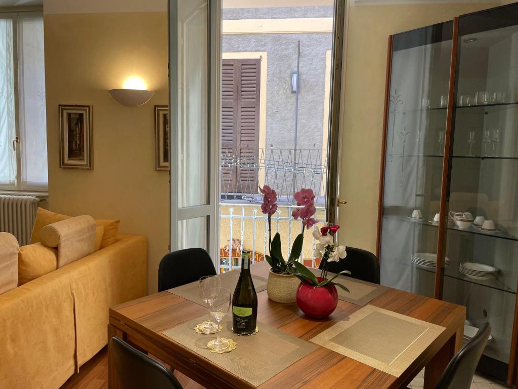 una mesa de comedor con una botella de vino y flores. en Casa De Pellegrin Bellagio Lake Como, en Bellagio