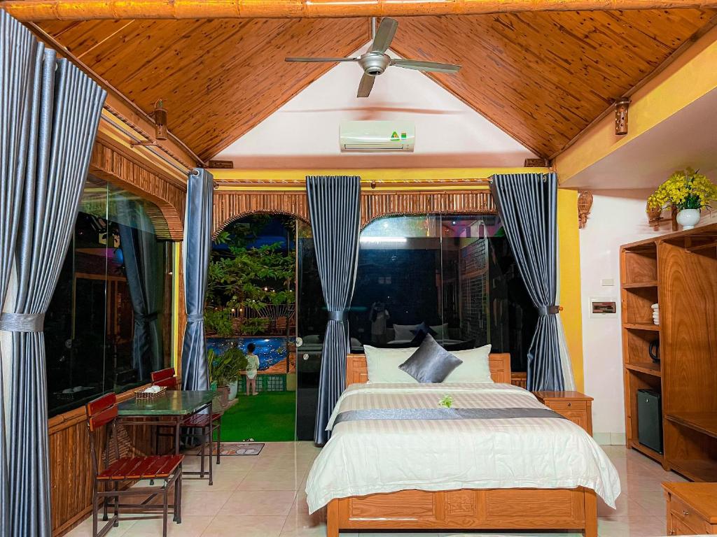 a bedroom with a bed and a table and a window at Tam Coc Sunrise Homestay in Ninh Binh