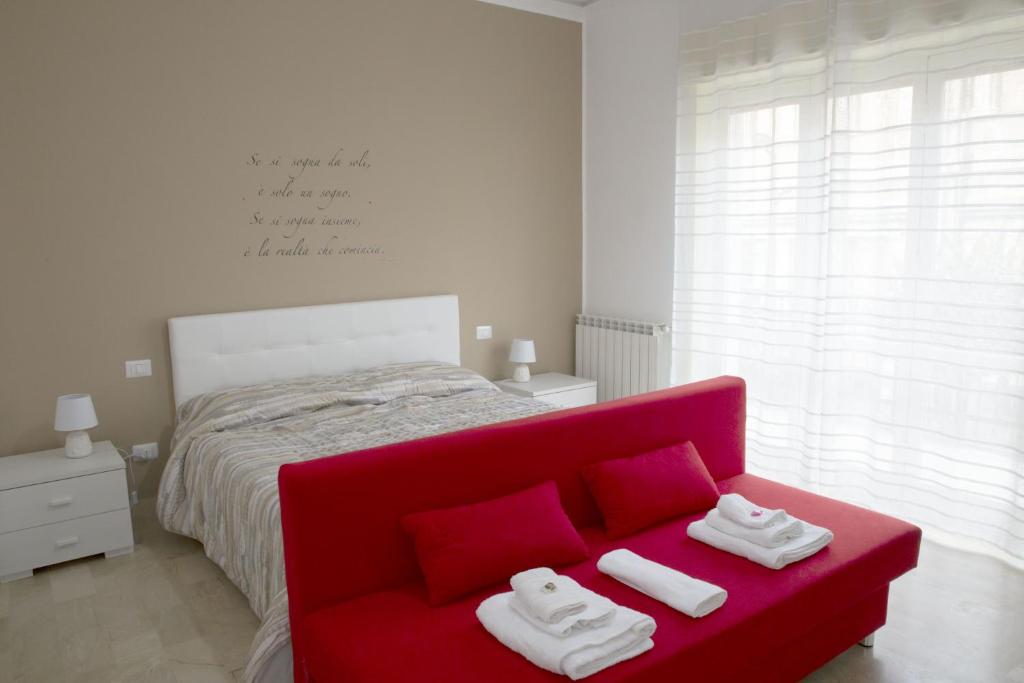 1 dormitorio con sofá rojo y cama en A Quattro Passi, en San Cataldo
