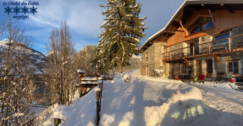 a ski lodge in the snow next to a tree at Le Chalet des Eulets in Bourg-Saint-Maurice