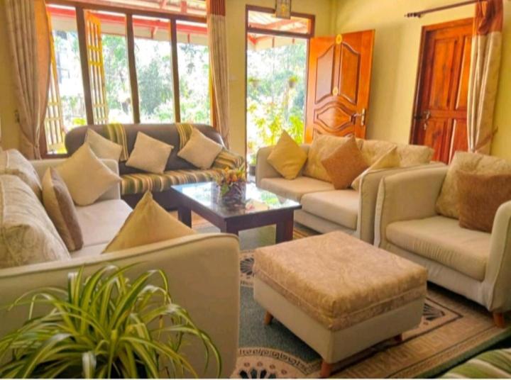 Sala de estar con sofás y mesa de centro en Vegetable Garden House en Nallathanniya
