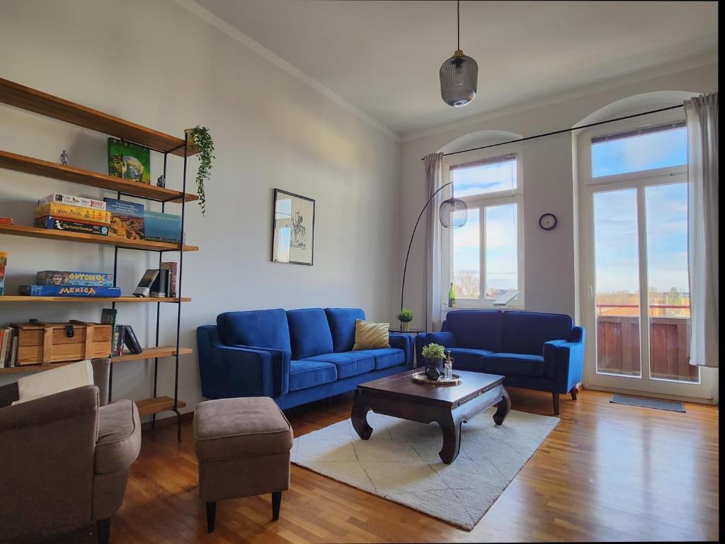 Sala de estar con sofás azules y mesa de centro en 4 Raum Wohnung mit Balkon auf 120sqm in Top Lage, en Dresden