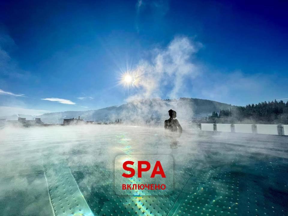BUKA Apart-Hotel & SPA في بوكوفِل: رجل يقف في حوض استحمام ساخن