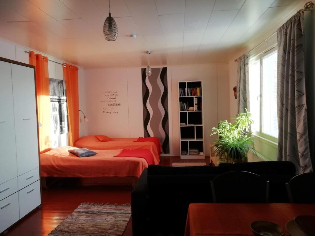 1 dormitorio con 2 camas y sofá en Kodit Tuulikinkatu, en Mikkeli