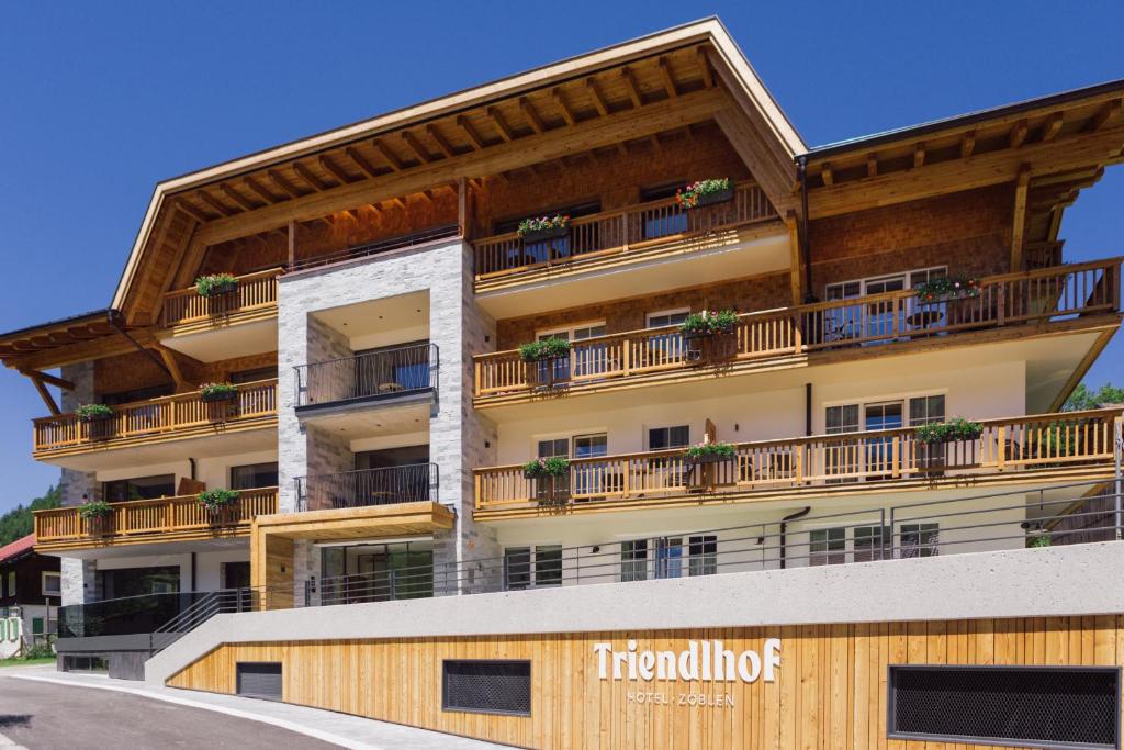 um edifício de apartamentos com varandas e plantas nele em Triendlhof em Zöblen