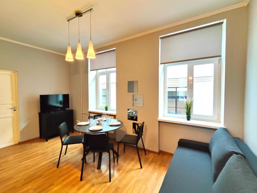 a living room with a table and a blue couch at Gleznotaju Old Town Two Bedroom Apartment in Rīga