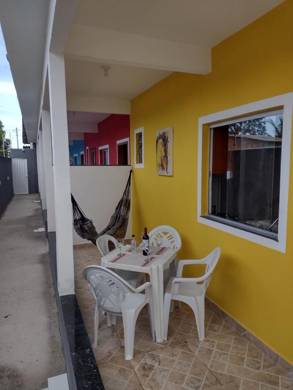 una mesa y sillas en una habitación con una pared amarilla en Casa1 Sua casa de férias perto das praias, en Porto Seguro