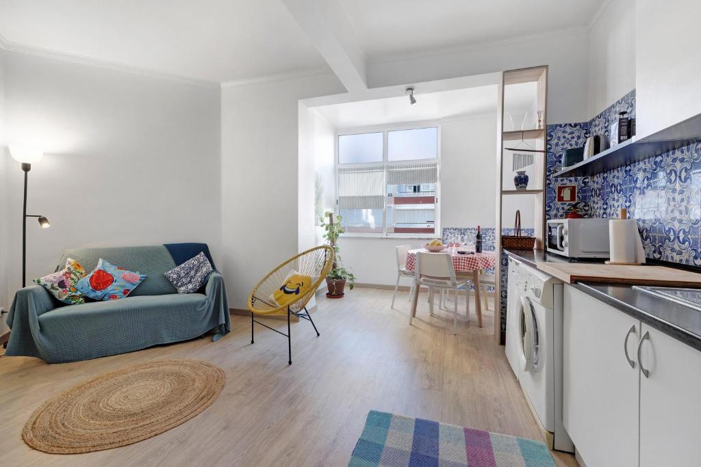 a living room with a couch and a kitchen at The Beach Place in Costa da Caparica