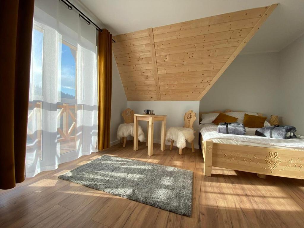 1 dormitorio con cama y ventana grande en Willa Pod Wyciągiem, en Spytkowice