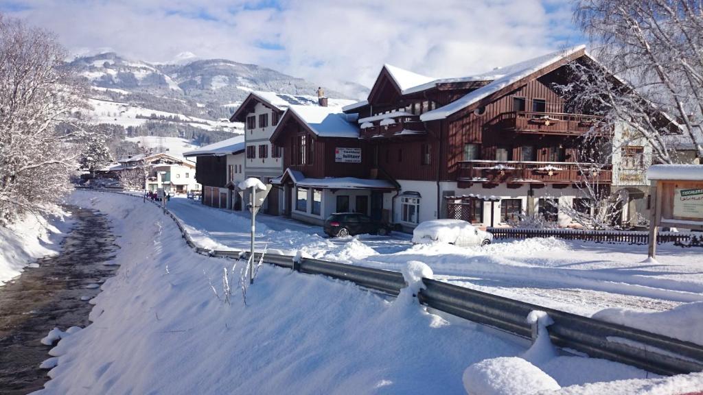 a snow covered street in front of a building at Ferienhaus Islitzer in Hollersbach im Pinzgau