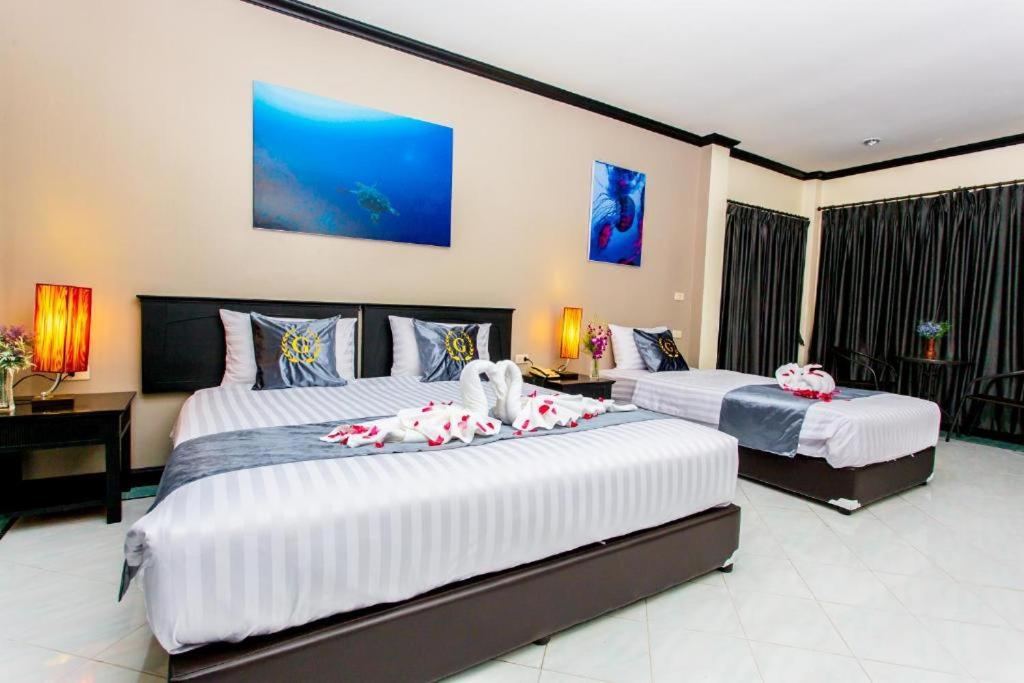 a bedroom with two beds and a desk at Royal Vista in Patong Beach