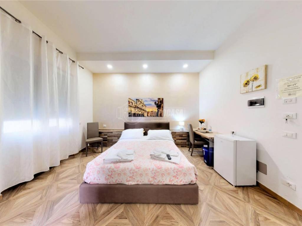 ein Schlafzimmer mit einem großen Bett und einem Schreibtisch in der Unterkunft LECCE MON AMOUR B&B in Lecce