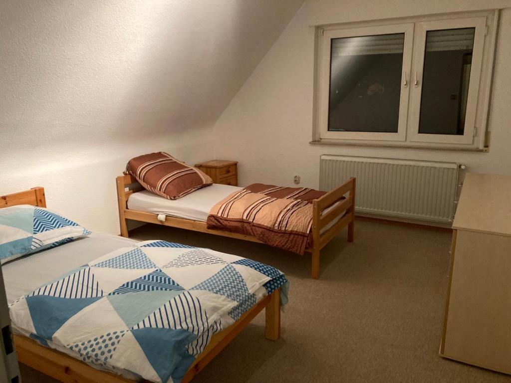 um quarto com 2 camas e uma janela em Monteurunterkunft Wiesental em Waghäusel