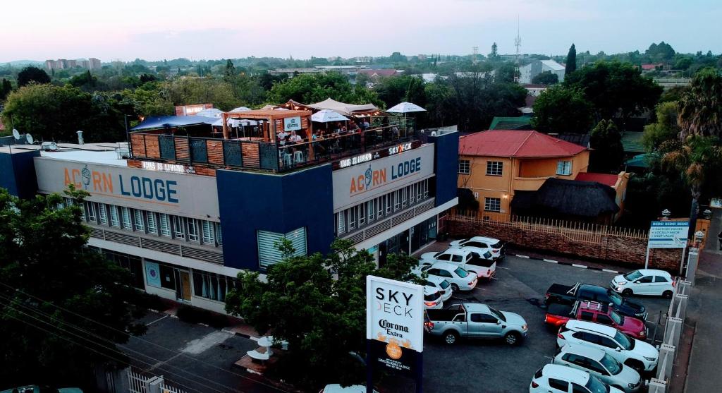un edificio con coches estacionados en un estacionamiento en Acorn Lodge & SKYDECK, en Potchefstroom