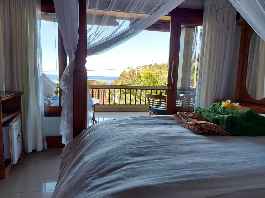 艾湄灣的住宿－Sama Sama Amed，一间卧室设有一张床,享有海景
