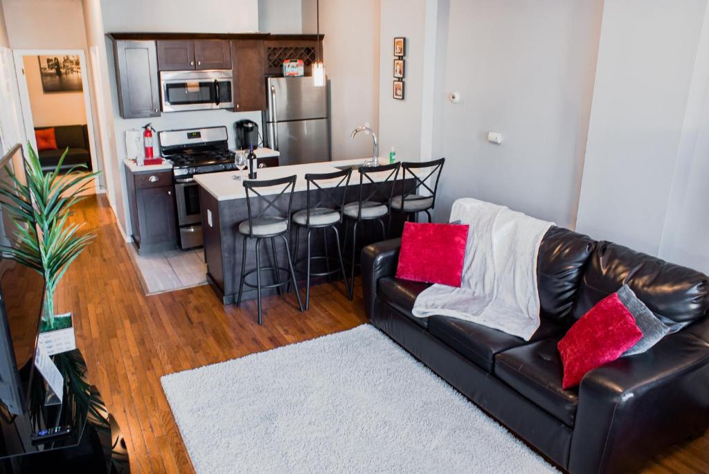 a living room with a leather couch and a kitchen at Lovely 2BR apartment by Wooster Square- great neighborhood in New Haven