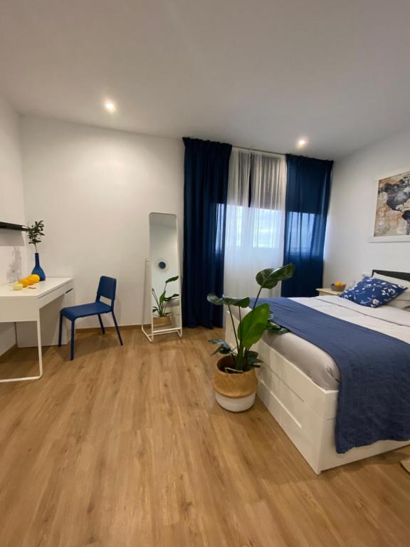 a bedroom with a bed and a desk and a table at Hostal Orange Vibes in Paterna