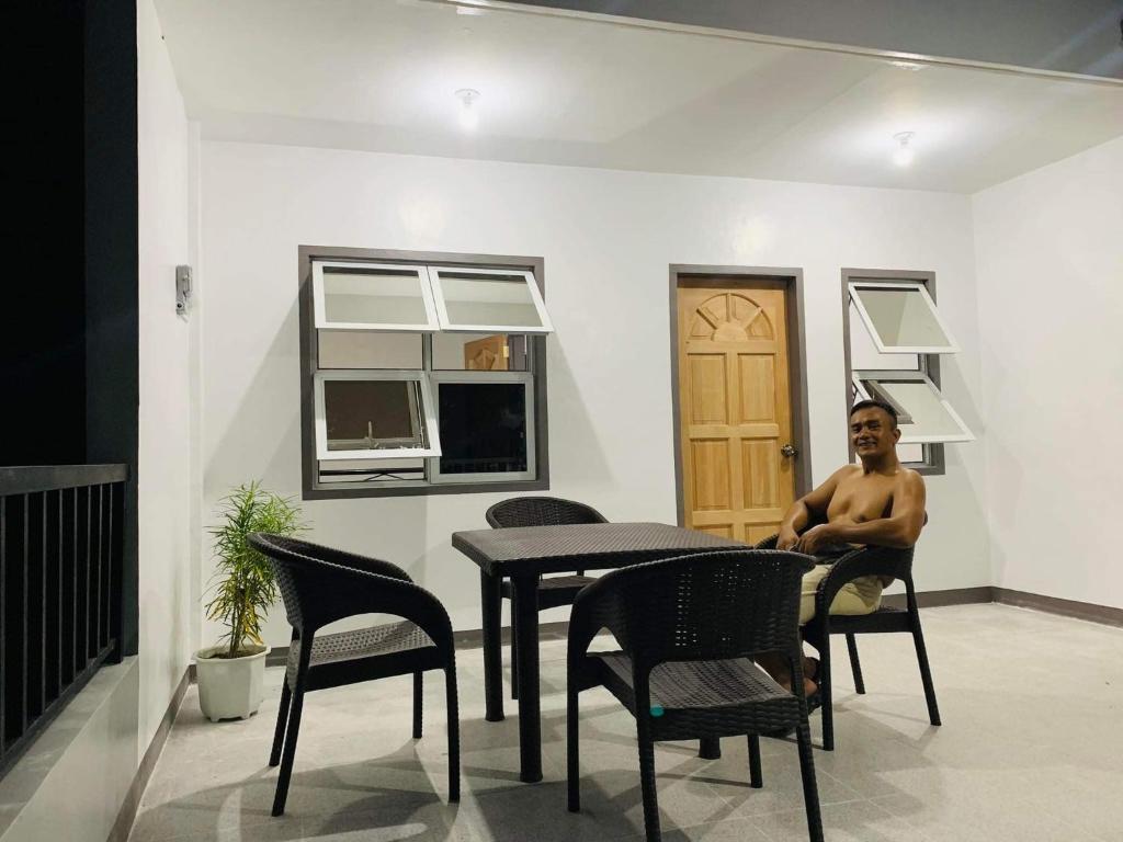 a man sitting at a table in a room at Romblon Transient House in Romblon