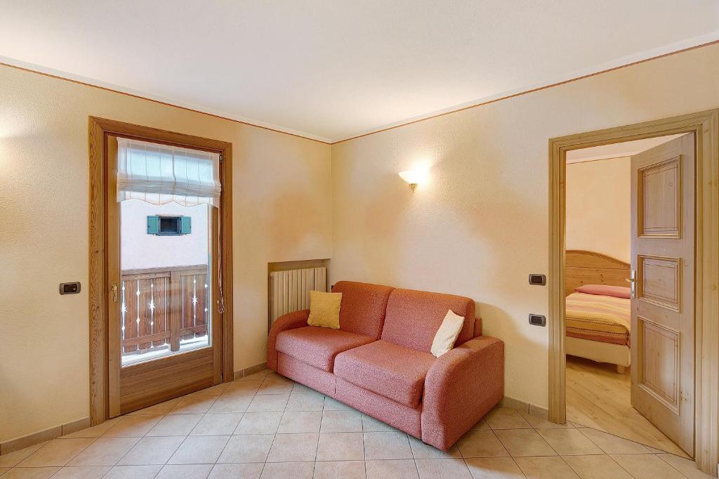 sala de estar con sofá rojo y ventana en Baita Pemont en Livigno