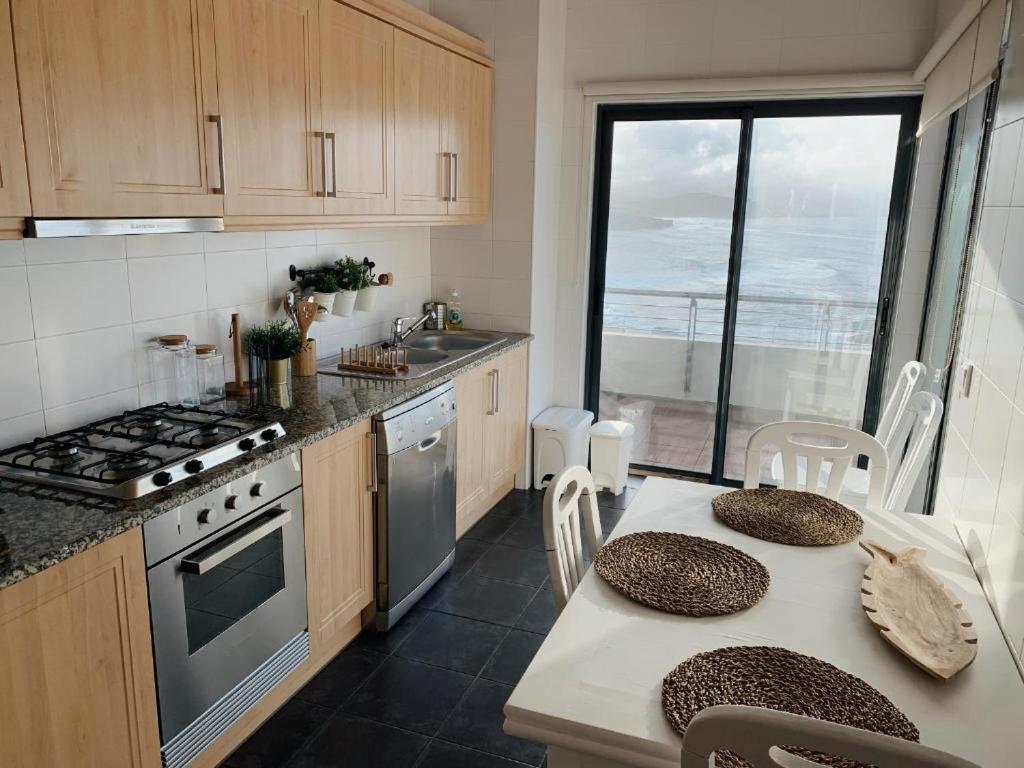 una cocina con una mesa y una estufa horno superior en Monte Azul Penthouse, en Ribeira Grande