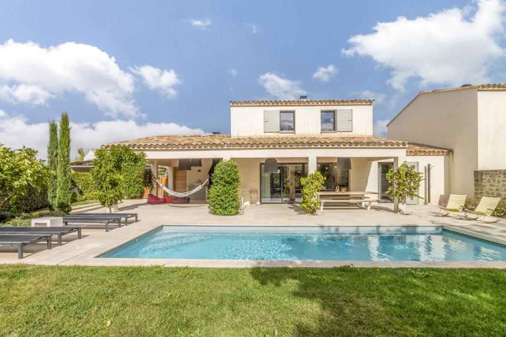 una villa con piscina di fronte a una casa di Les Cerisiers du Mont Ventoux a Malaucène