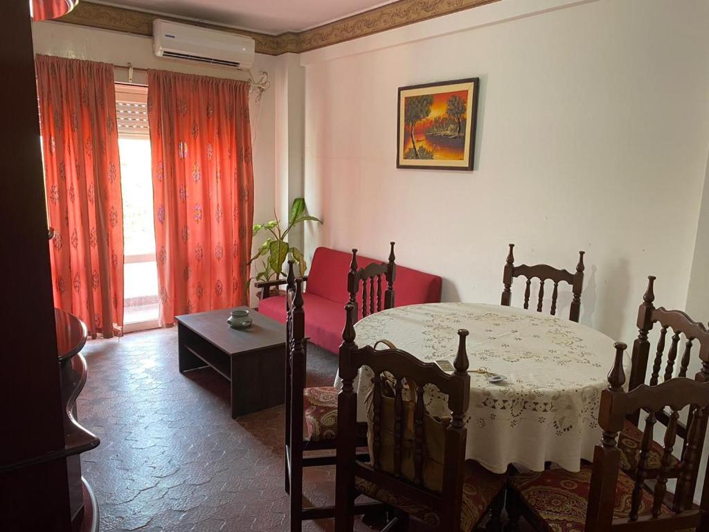 uma sala de estar com uma mesa e uma cortina vermelha em Departamento completo a dos cuadras de la plaza principal , sin ascensor por el momento y con cochera em San Ramón de la Nueva Orán
