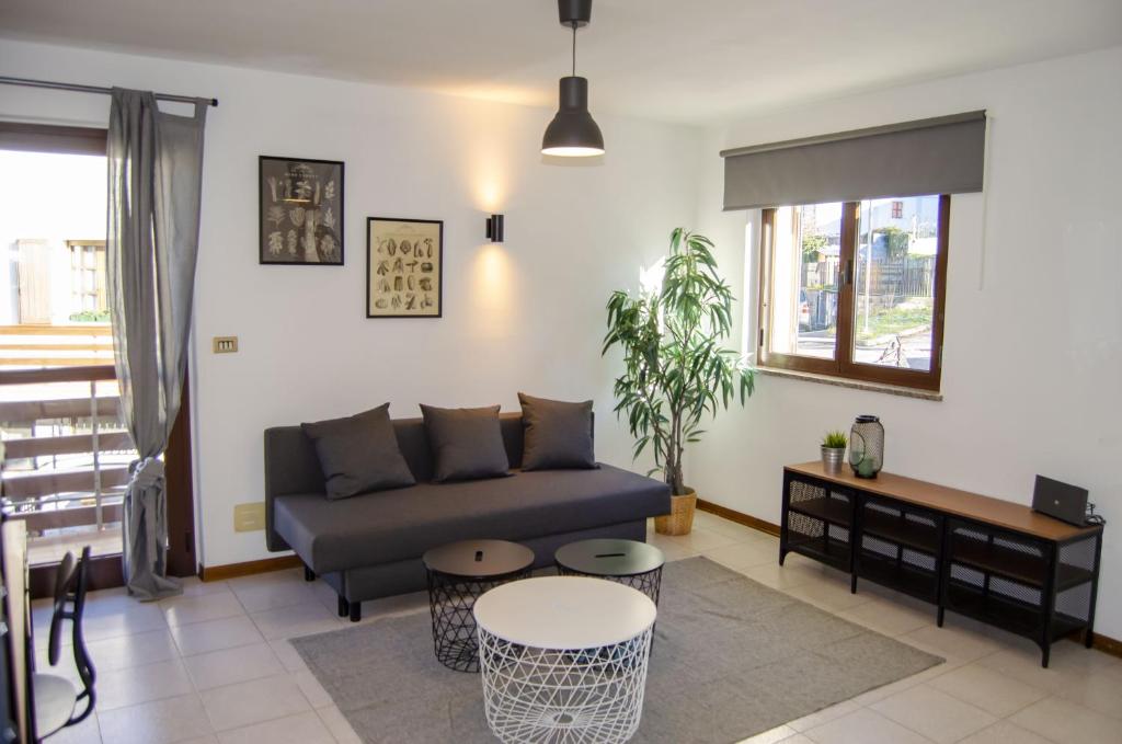 ein Wohnzimmer mit einem Sofa und einem Tisch in der Unterkunft BBkey La casetta Arta Terme in Arta Terme