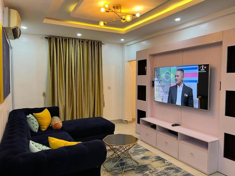 a living room with a couch and a flat screen tv at Exquisite 2-Bedroom Apt in Oniru in Lagos