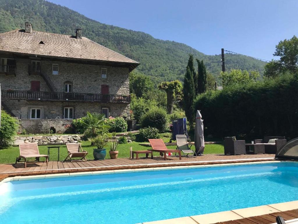 a house and a swimming pool in front of a house at La Perle de la Lauzière, chambres d hôtes in Argentine