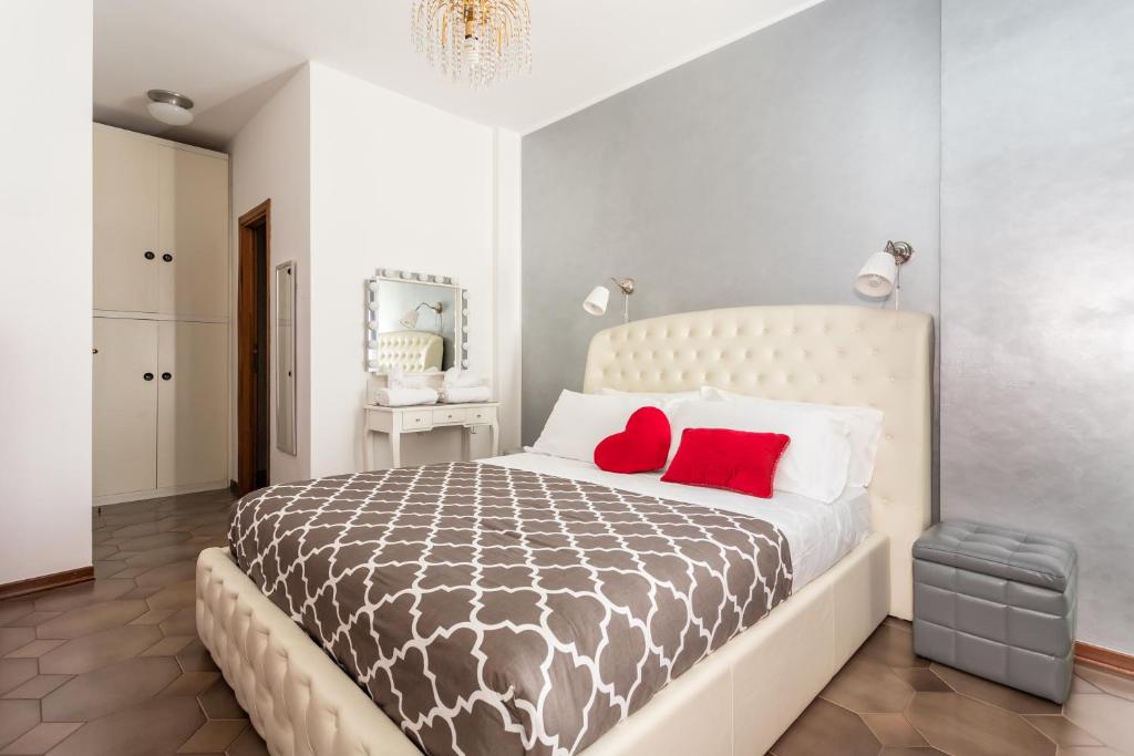 sypialnia z dużym łóżkiem z 2 czerwonymi poduszkami w obiekcie Cagliari Centro Città Rooms w Cagliari