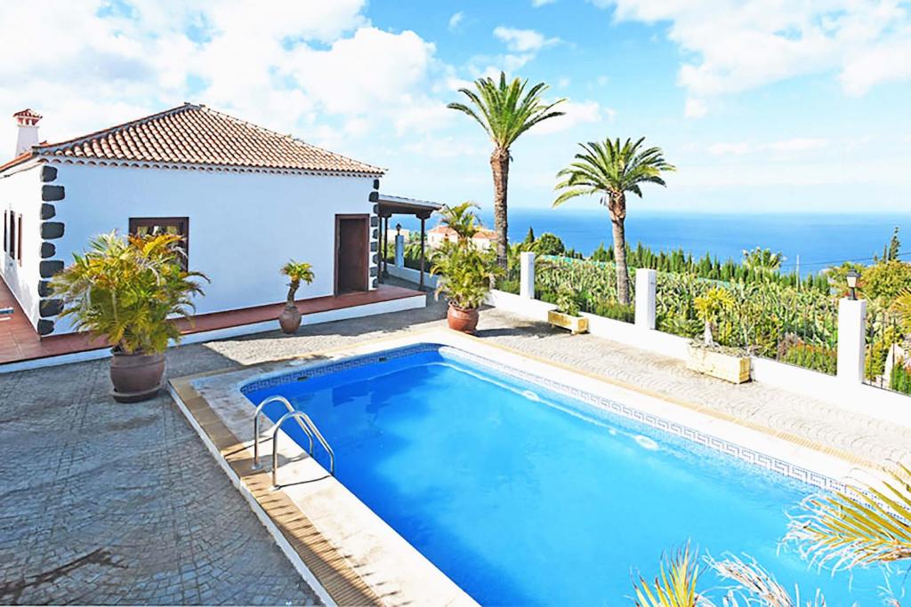 a villa with a swimming pool and the ocean at Villa Don Pedro in Tijarafe