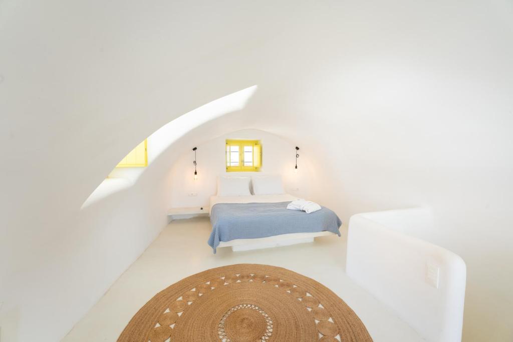 um quarto com uma cama num quarto branco em Anelia House em Oia