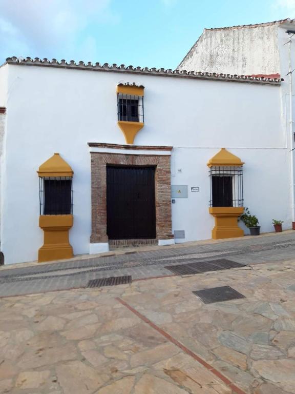 un edificio blanco con puertas y ventanas negras en Casa Rural La Maestra en Atajate