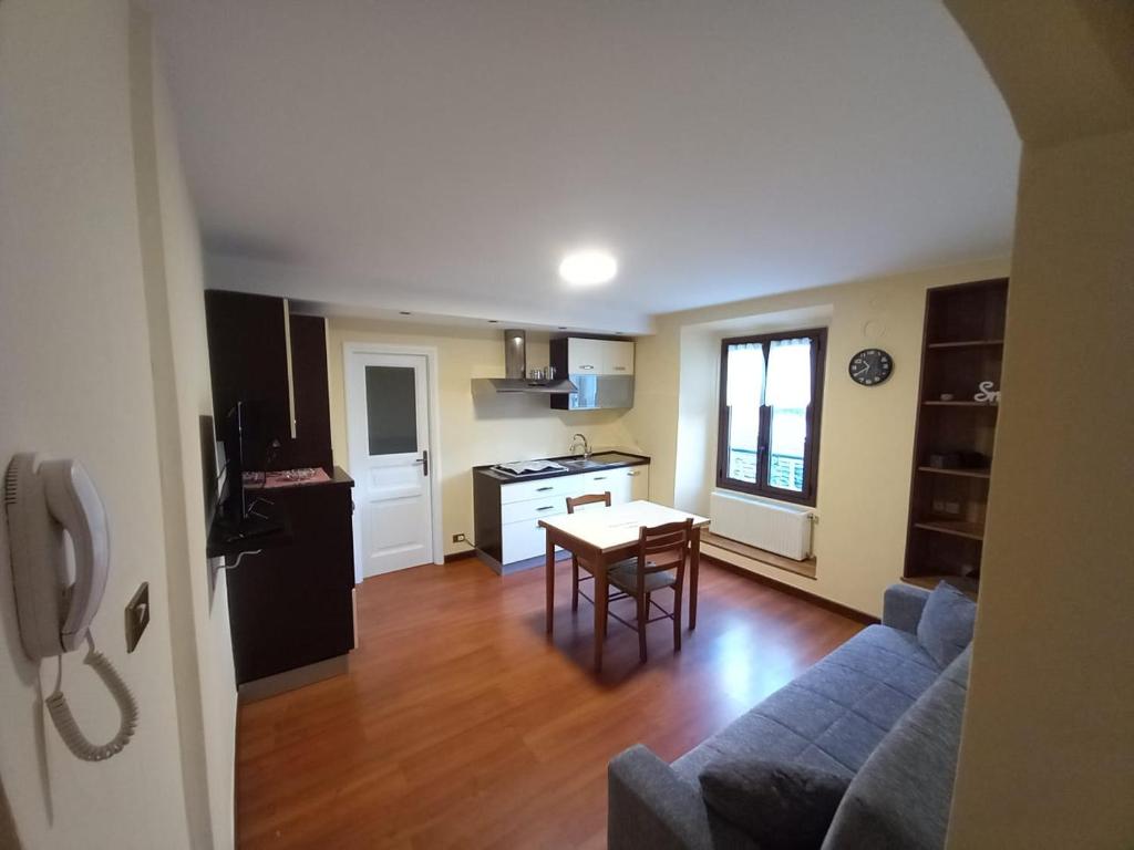 eine Küche und ein Wohnzimmer mit einem Sofa und einem Tisch in der Unterkunft Appartamento Sophie LT in Santa Maria Maggiore