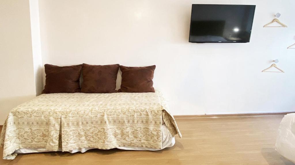1 dormitorio con 1 cama y TV en la pared en CORD0301 Gran Studio a metros del Obelisco en Buenos Aires