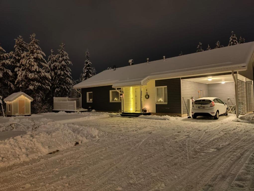 un coche aparcado frente a una casa en la nieve en House Venni, en Rovaniemi