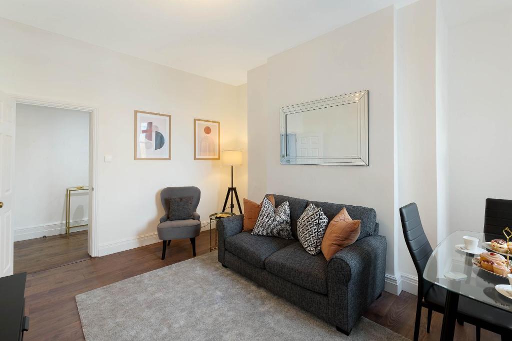 a living room with a couch and a table at Luxury Chelsea Flat in London