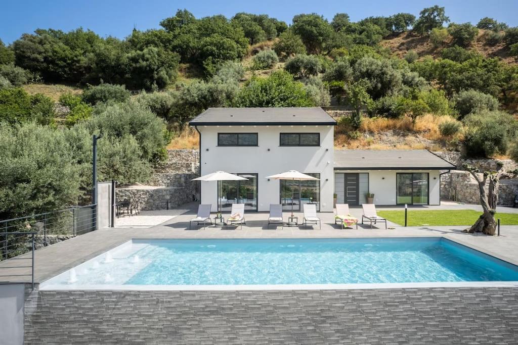 una casa con piscina di fronte a una casa di 3 Bedroom Modern Villa, Pool, Savoca, East Sicily a Casalvecchio Siculo