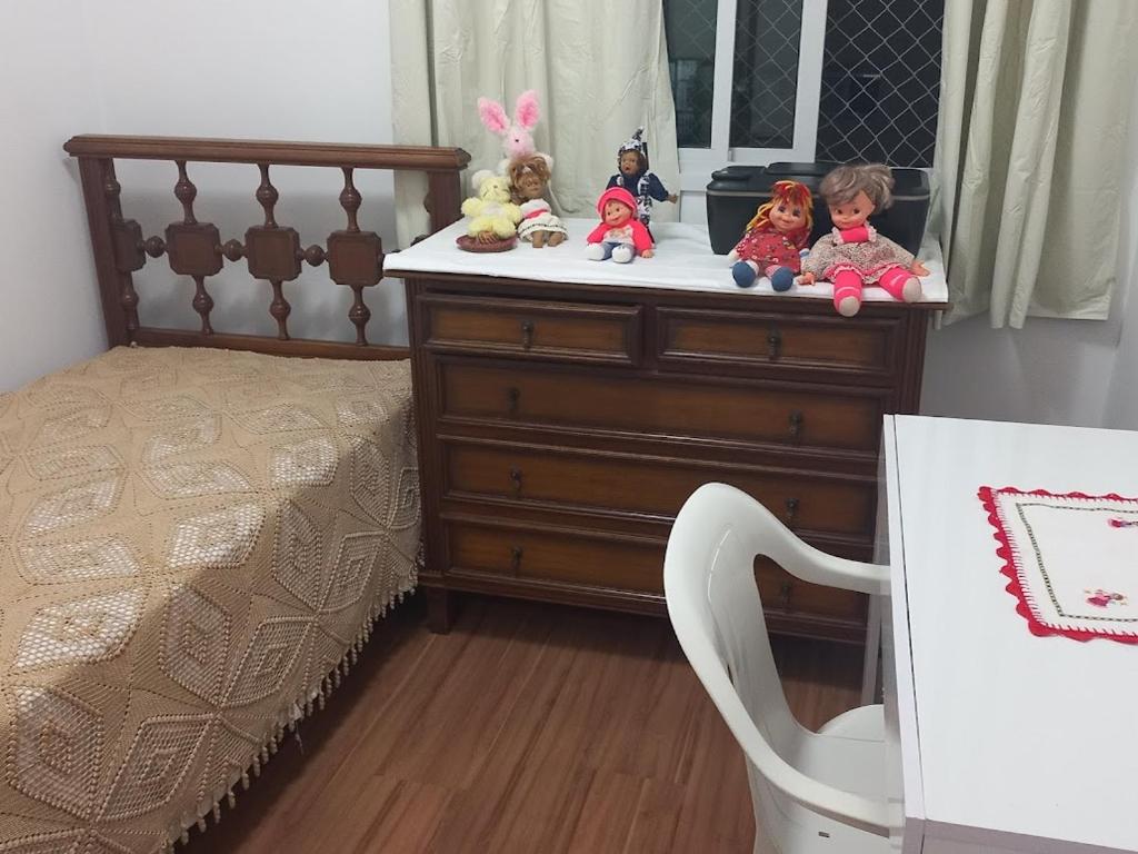 Un dormitorio con una cama y un tocador con muñecas. en Anúnicio Removido - Não Disponível, en São Paulo