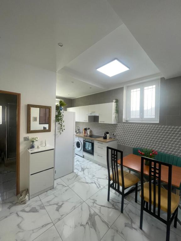 une cuisine avec une table, des chaises et un réfrigérateur dans l'établissement Nice Libération, à Nice