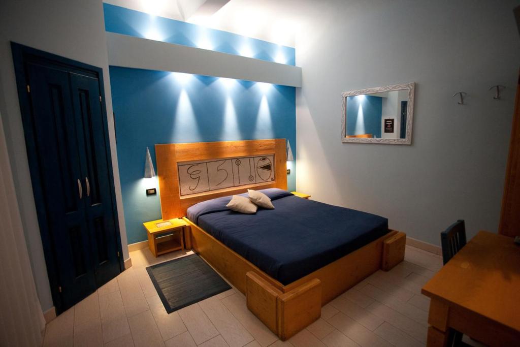 Schlafzimmer mit einem Bett mit blauer Wand in der Unterkunft Locanda dei Poeti Rooms & Apartments in Florenz