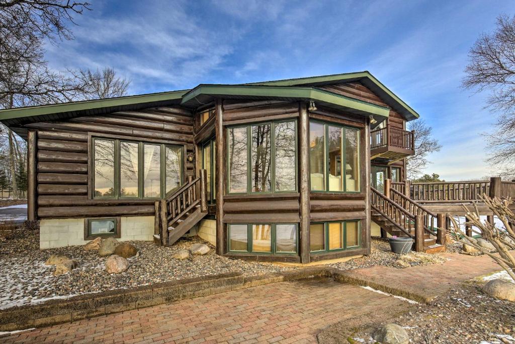 a log cabin with large windows and a porch at Lake Nokomis Escape with Dock and Beach Access in Tomahawk